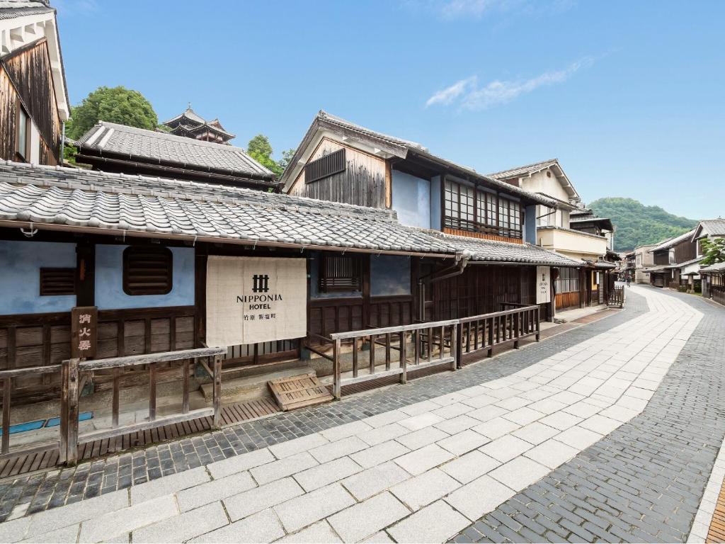 une rue vide dans un village avec des bâtiments en bois dans l'établissement NIPPONIA HOTEL Takehara Saltworks Town, à Takekara