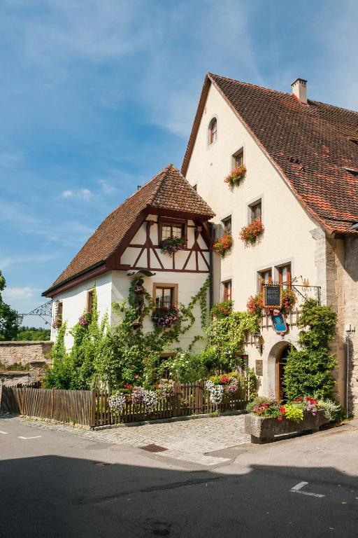 a white building with flower boxes on the windows at Burghotel in Rothenburg ob der Tauber