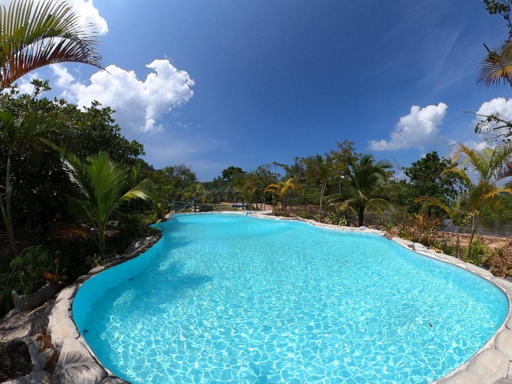 una gran piscina con agua azul y palmeras en Koh Pu Villa, en Ko Jum