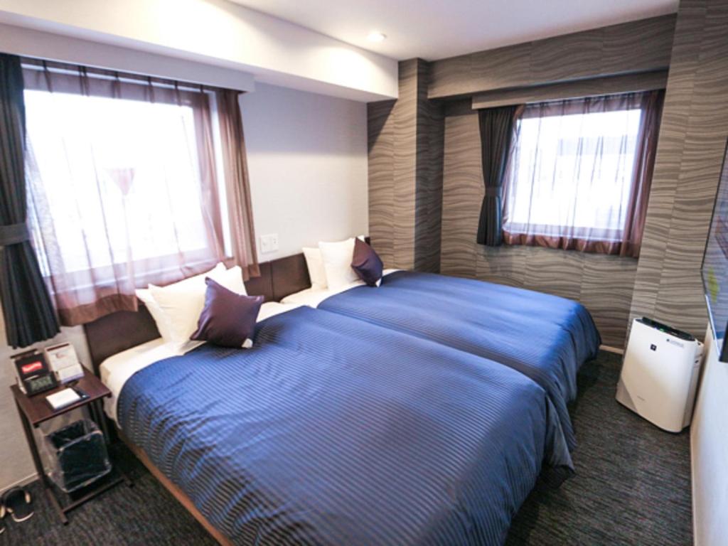 Postel nebo postele na pokoji v ubytování HOTEL LiVEMAX Tokyo Kanda-Ekimae