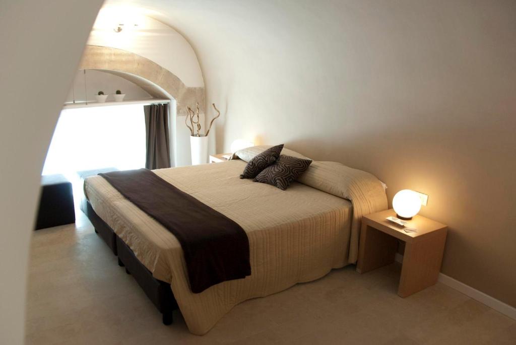 a bedroom with a bed with a large window at Le Stanze Del Sole in Ragusa