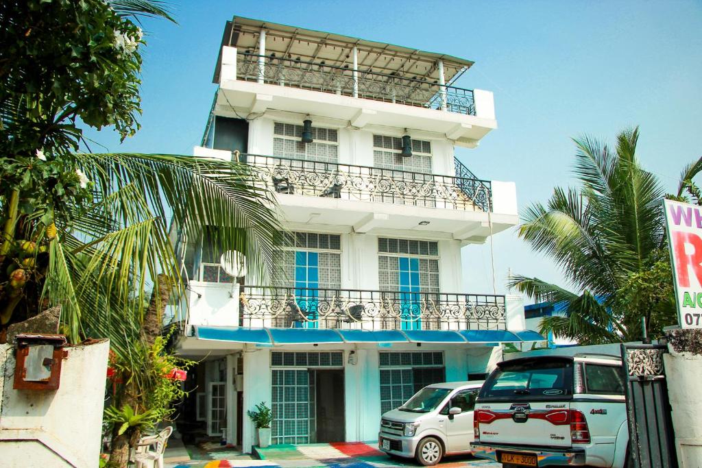 a white building with cars parked in front of it at White House in Wattala