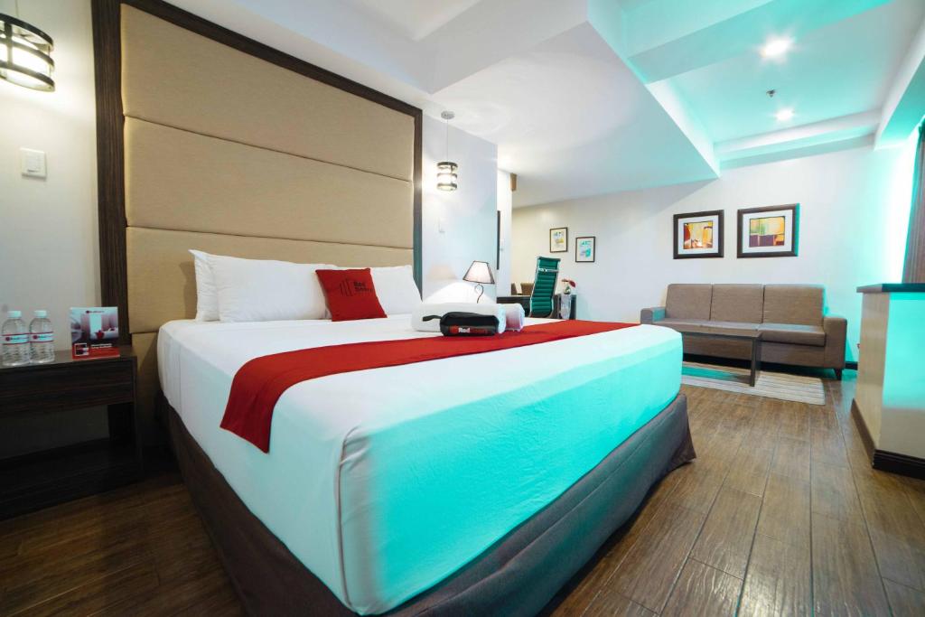 a bedroom with a large bed and a couch at RedDoorz Premium @ West Avenue Quezon City in Manila