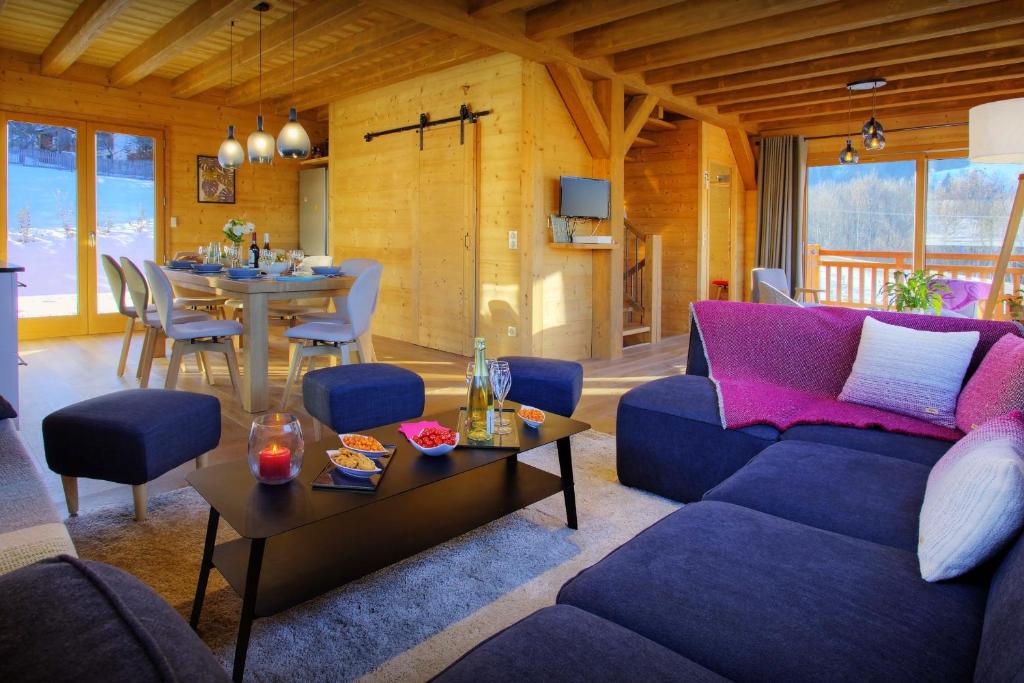 a living room with a purple couch and a table at Chalet Pajules - OVO Network in Le Fey