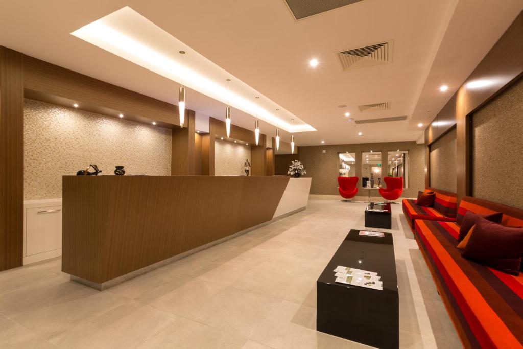 a lobby with a red couch and a counter at Boyalik Beach Hotel & Spa Cesme in Çeşme