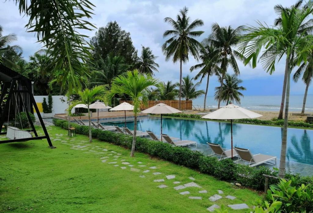 einen Pool im Resort mit Stühlen und Sonnenschirmen in der Unterkunft Tungtong Beach Villas in Ban Khao Khwang (2)