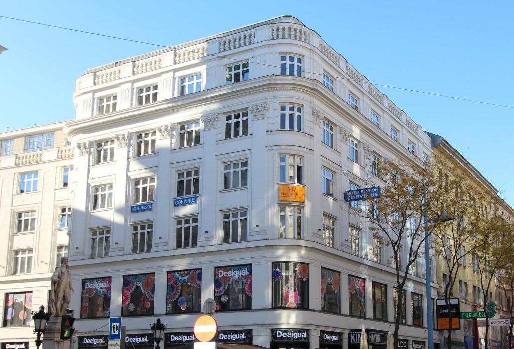 um edifício branco na esquina de uma rua em Hotel Corvinus Vienna - Newly Renovated em Viena