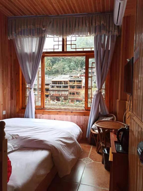Postel nebo postele na pokoji v ubytování Fenghuang Memory Linjiang Inn
