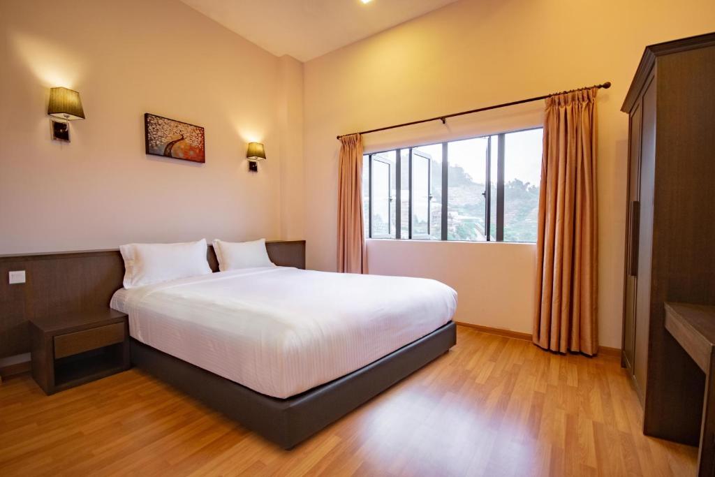 a bedroom with a bed and a large window at Nova Highlands Hotel in Cameron Highlands