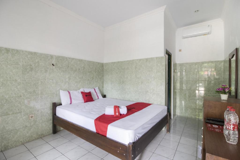 a bedroom with a bed with red and white pillows at RedDoorz @ Sagan Jogja 2 in Yogyakarta