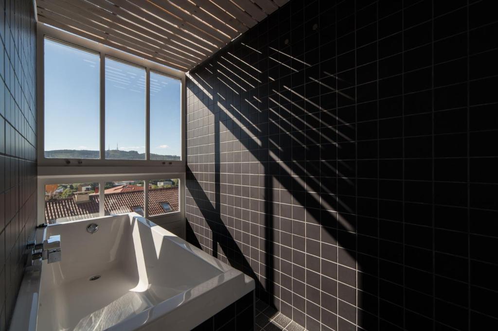 a bathroom with a white sink and a window at Moure Hotel in Santiago de Compostela