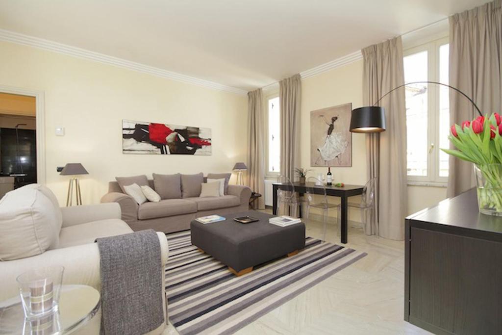 een woonkamer met een bank en een tafel bij Crispi Luxury Apartments - My Extra Home in Rome