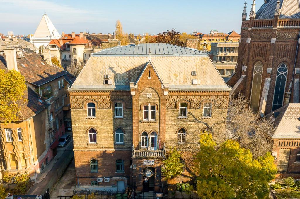 un vecchio edificio in mattoni con una torre dell'orologio in una città di Dominik Panzió a Budapest