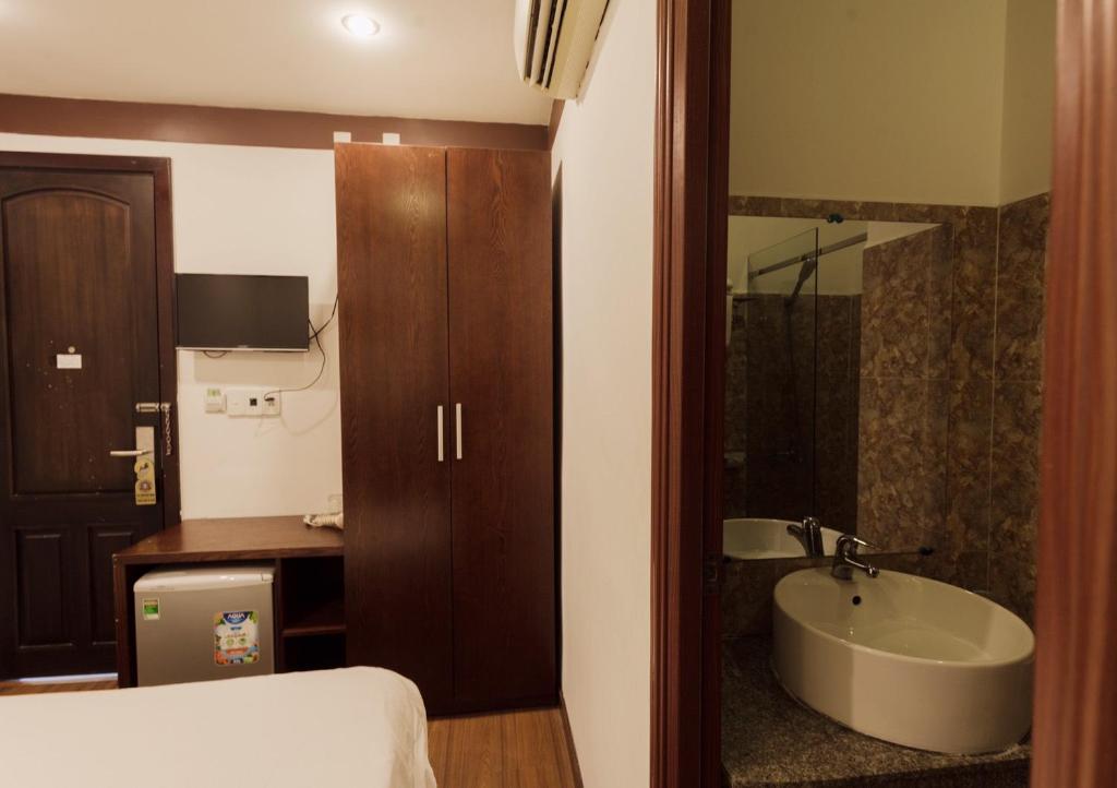 a bathroom with a sink and a bed and a tub at Brown Bean 2 Hotel in Danang