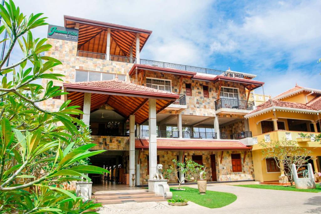 a large building with a balcony in front of it at Jasmin Villa Ayurveda Resort in Negombo