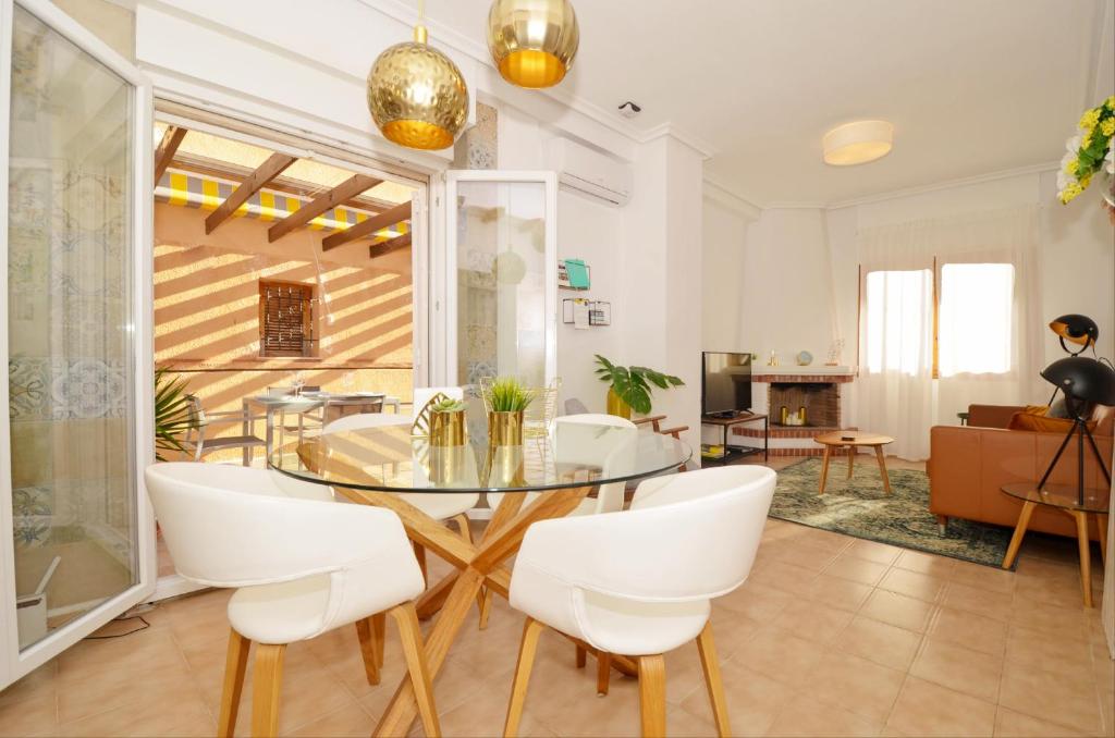 une salle à manger avec une table en verre et des chaises blanches dans l'établissement Punta Prima Pleasure, à Torrevieja