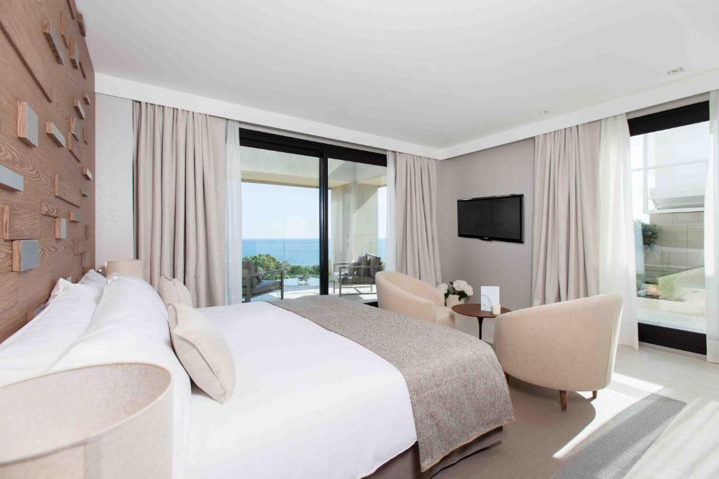 マルベーリャにあるジ オアシス バイ ドン カルロス リゾートの白いベッドルーム(大型ベッド1台、テレビ付)