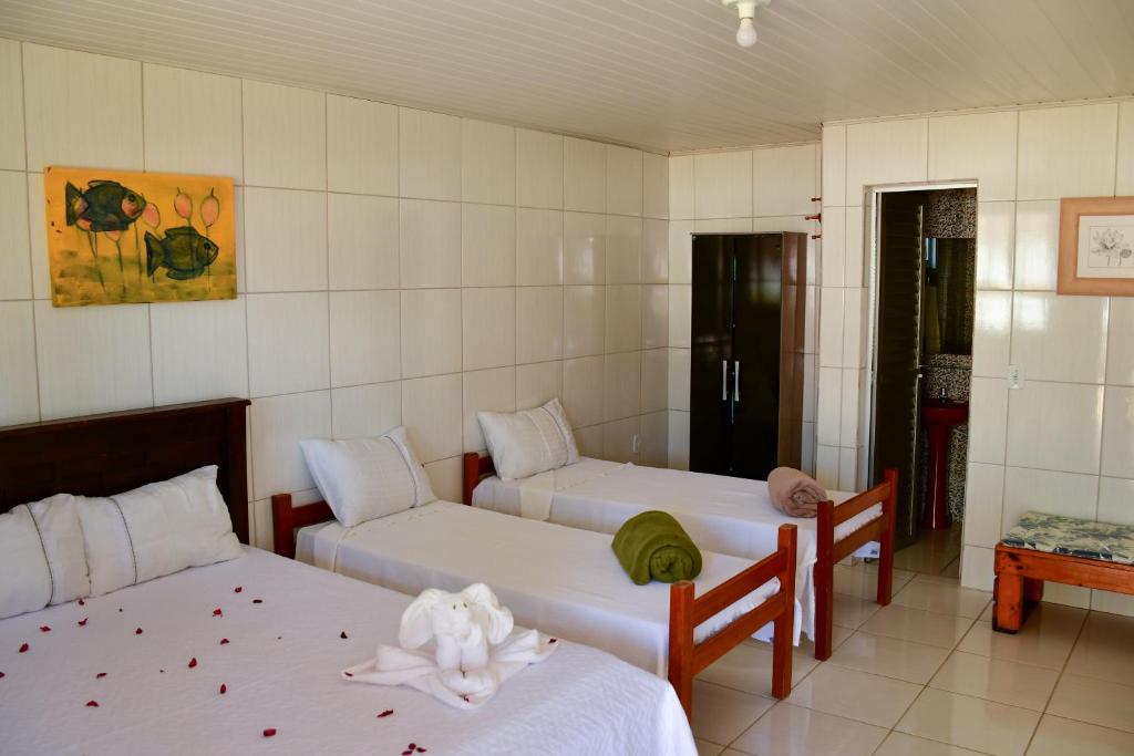 a room with two beds and two couches at Chalés de Peroba in Maragogi