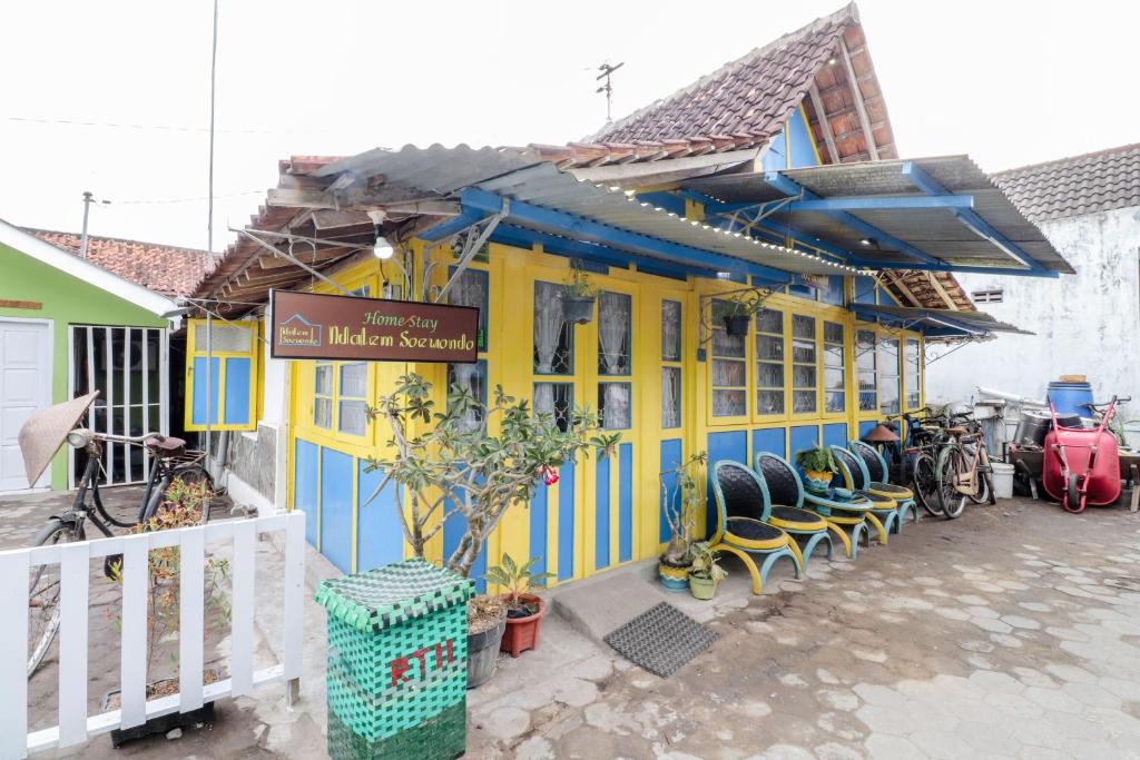 a blue and yellow building with bikes parked outside at Homestay Ndalem Soewondo in Yogyakarta