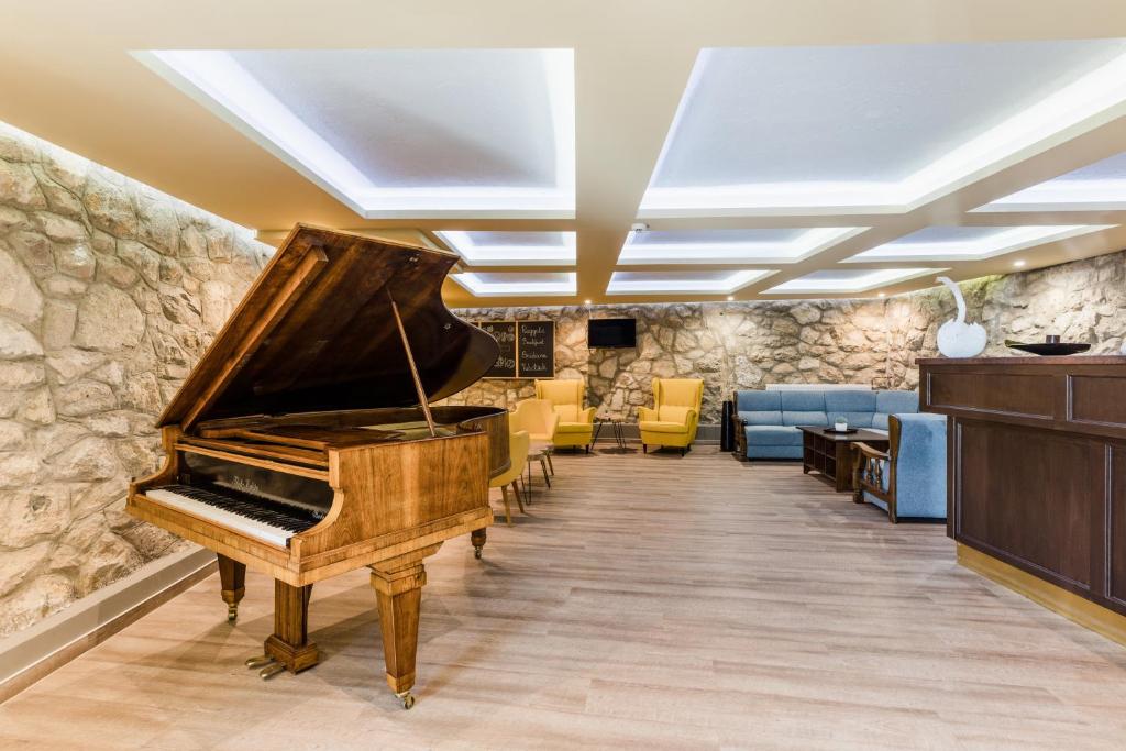 - un piano dans une salle d'attente avec des chaises dans l'établissement Amstel Hattyú Panzió -Érintésmentes bejelentkezés, à Győr
