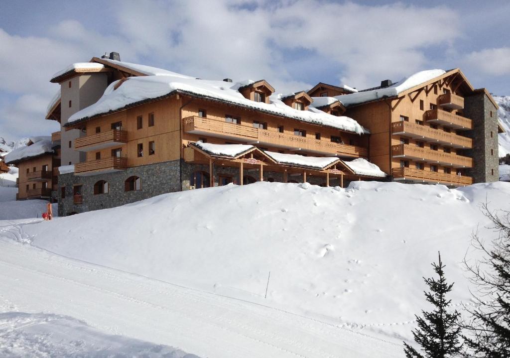 a large building with a pile of snow in front of it at Le Vancouver in La Plagne