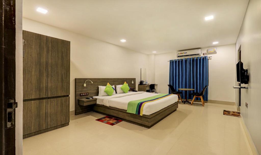 a bedroom with a bed and a desk and a chair at Treebo Trend Arna Residency in Guwahati