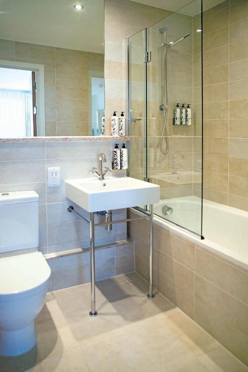 a bathroom with a sink and a shower and a toilet at St Moritz Hotel and Cowshed Spa in Polzeath