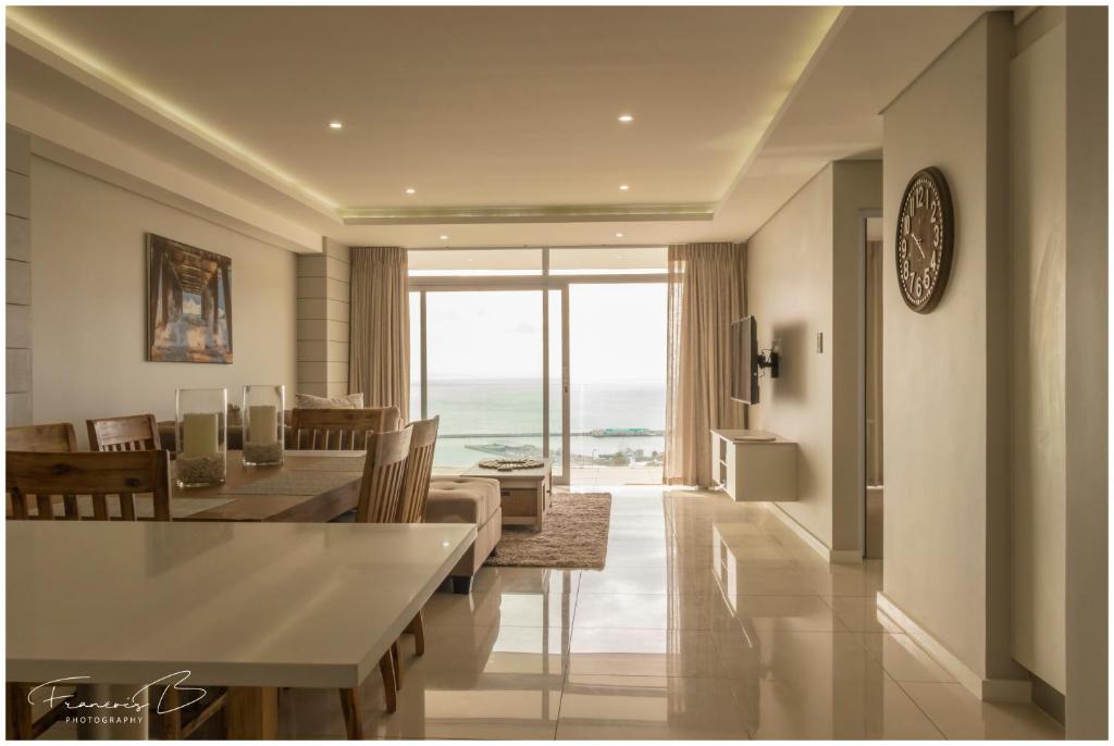 a dining room and living room with a view of the ocean at View @ The Bay Apartments in Mossel Bay