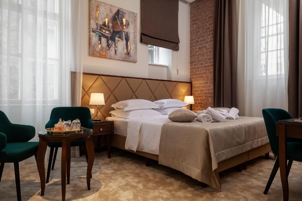 ein Hotelzimmer mit einem Bett, einem Tisch und Stühlen in der Unterkunft Luxury rooms Tilia in Zagreb