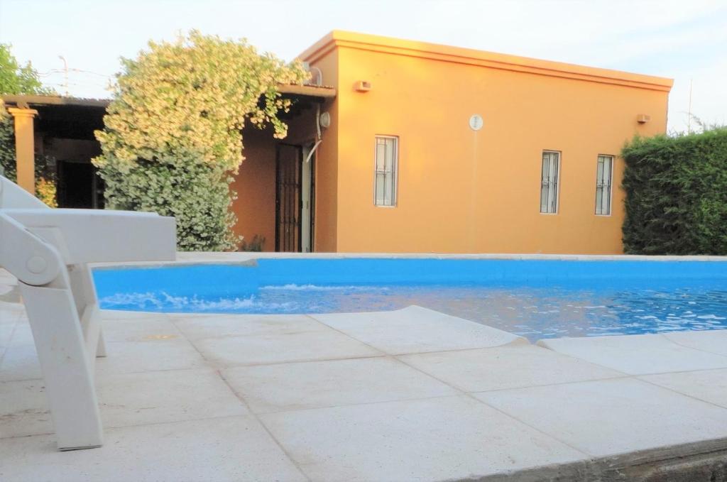 a blue swimming pool in front of a house at Jazmin de Lluvia in Vistalba