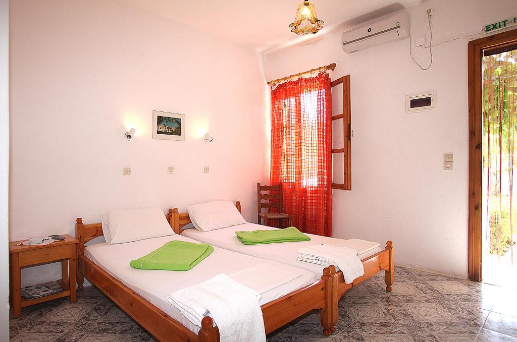 1 dormitorio con 2 camas y ventana en Karidies en Skopelos Town