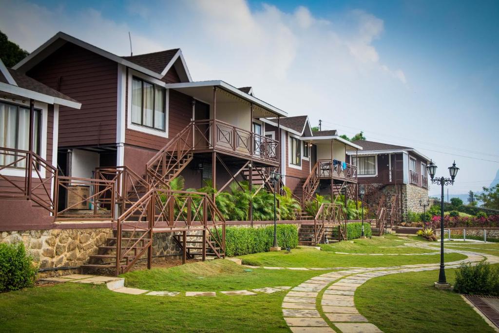 a row of houses with stairs and grass at Green Velvet Resort-Near Pawna Lake in Lonavala