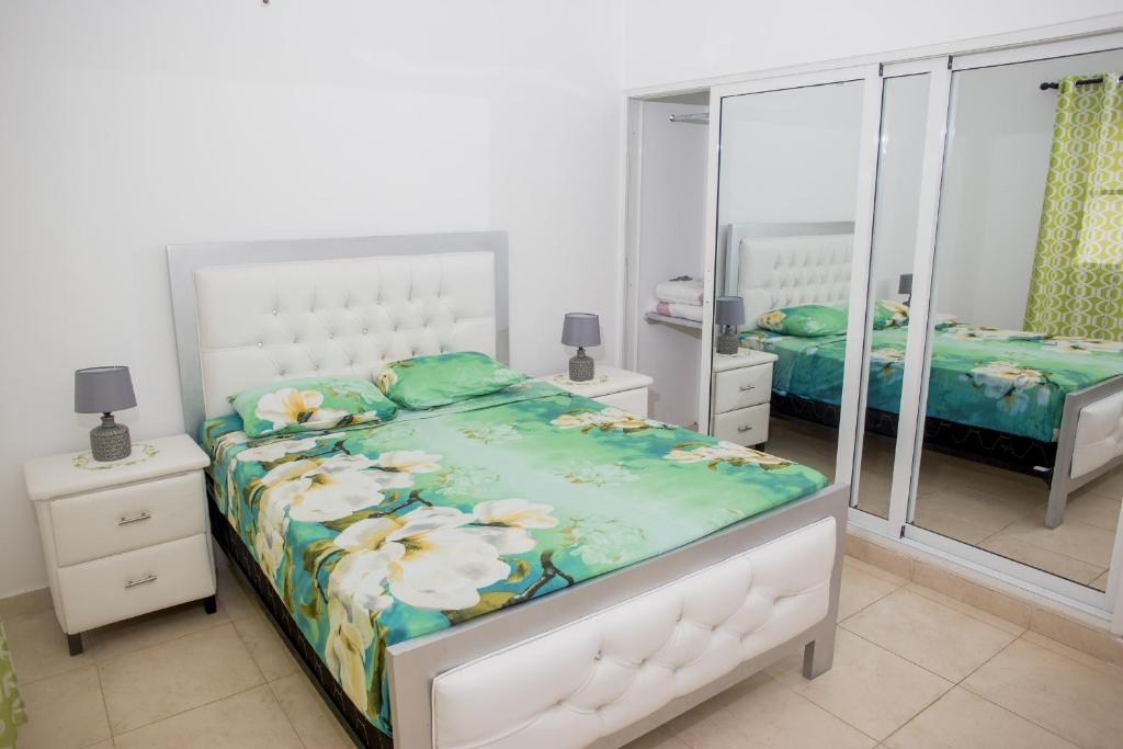 a bedroom with two beds and a mirror at Bela Villa Apartment IDA in Bayahibe