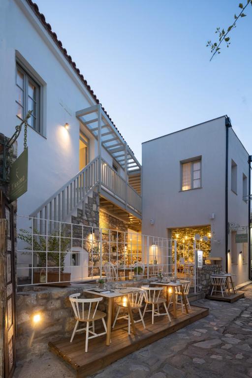 a patio with a table and chairs in front of a building at L Anima in Skiathos
