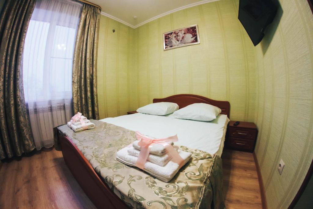 a bedroom with a bed with two dolls on it at Hotel Dinastiya in Nizhny Novgorod