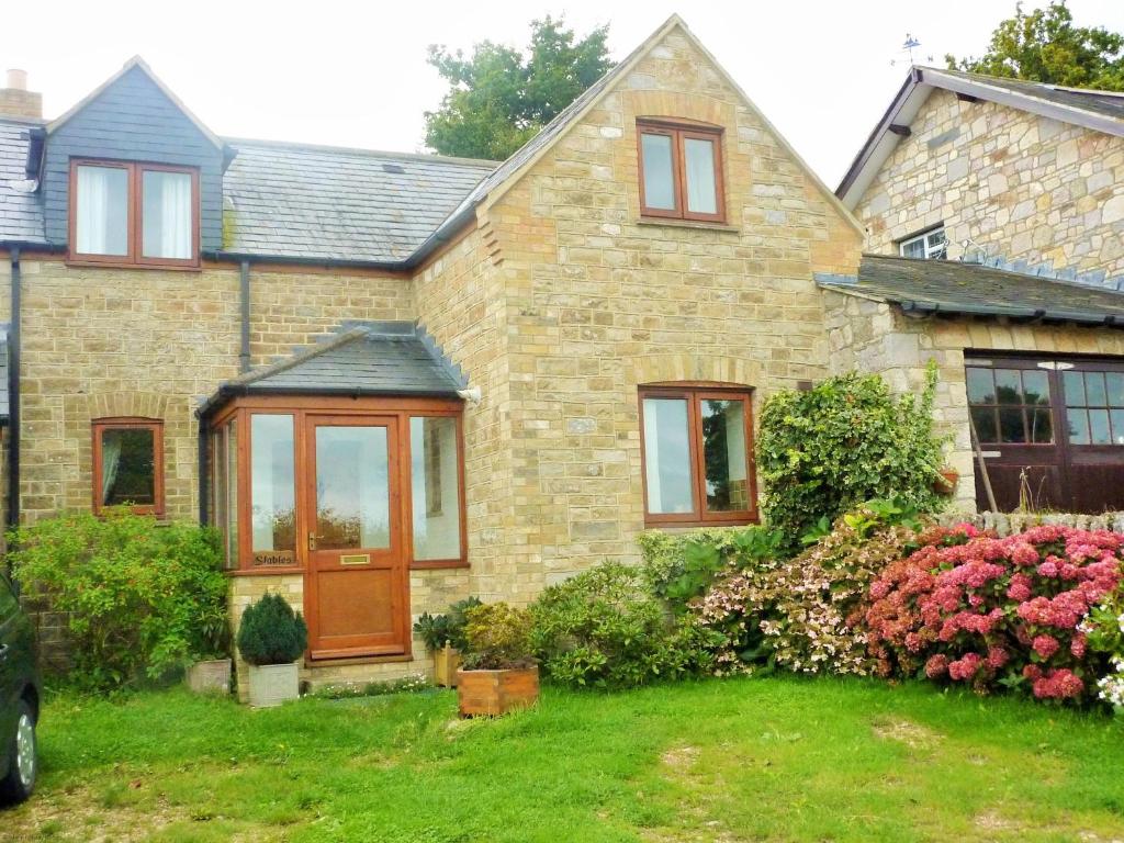 una casa in mattoni con una porta in legno nel cortile di The Stables a Saint Helens