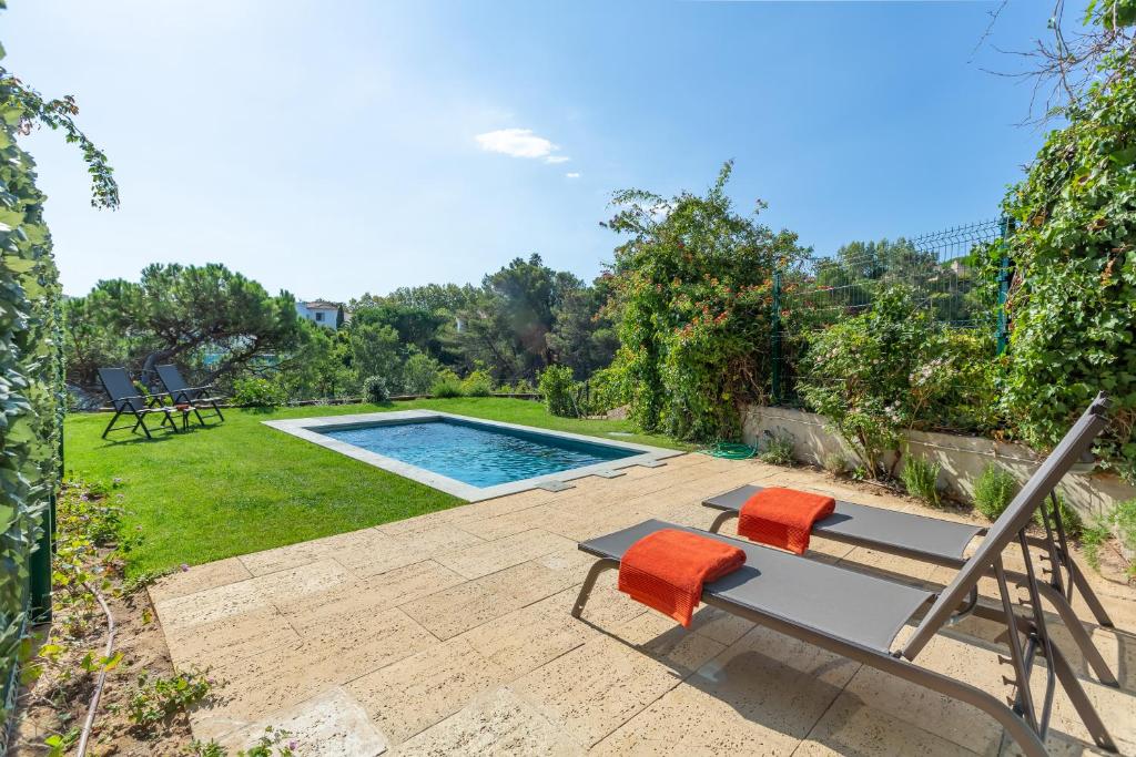 um quintal com uma piscina, uma mesa e cadeiras em Estoril House em Estoril