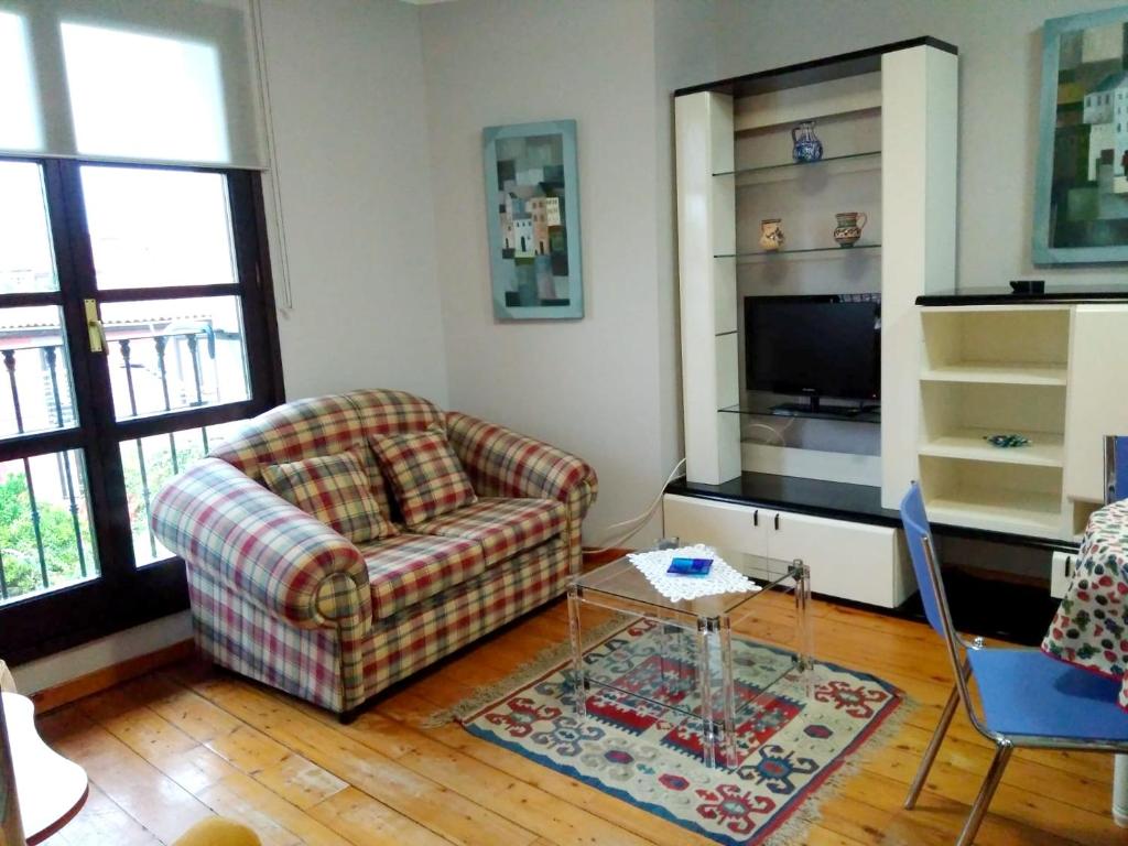 a living room with a couch and a tv at 2 bedrooms apartement at Llanes 200 m away from the beach with wifi in Llanes