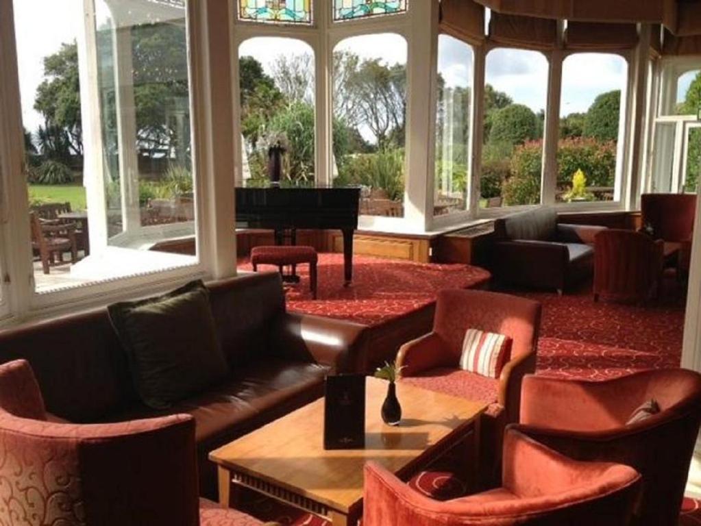 a living room filled with furniture and tables at Royal Bath Hotel & Spa Bournemouth in Bournemouth