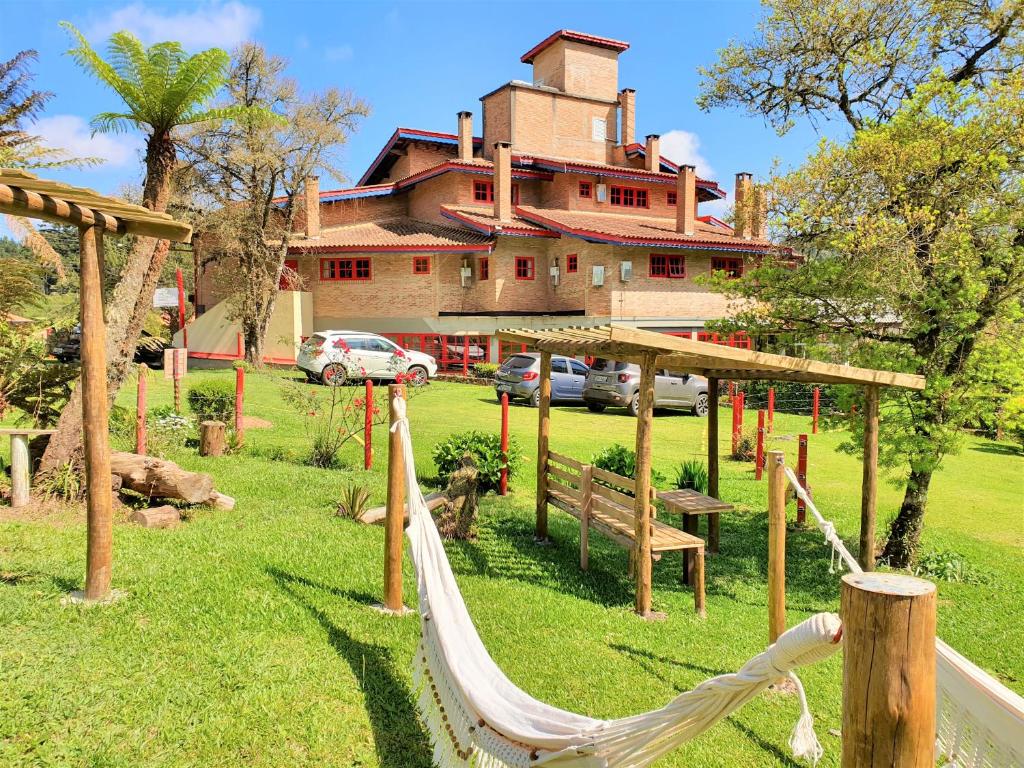a resort with a hammock in front of a house at Alas De La Sierra in Monte Verde