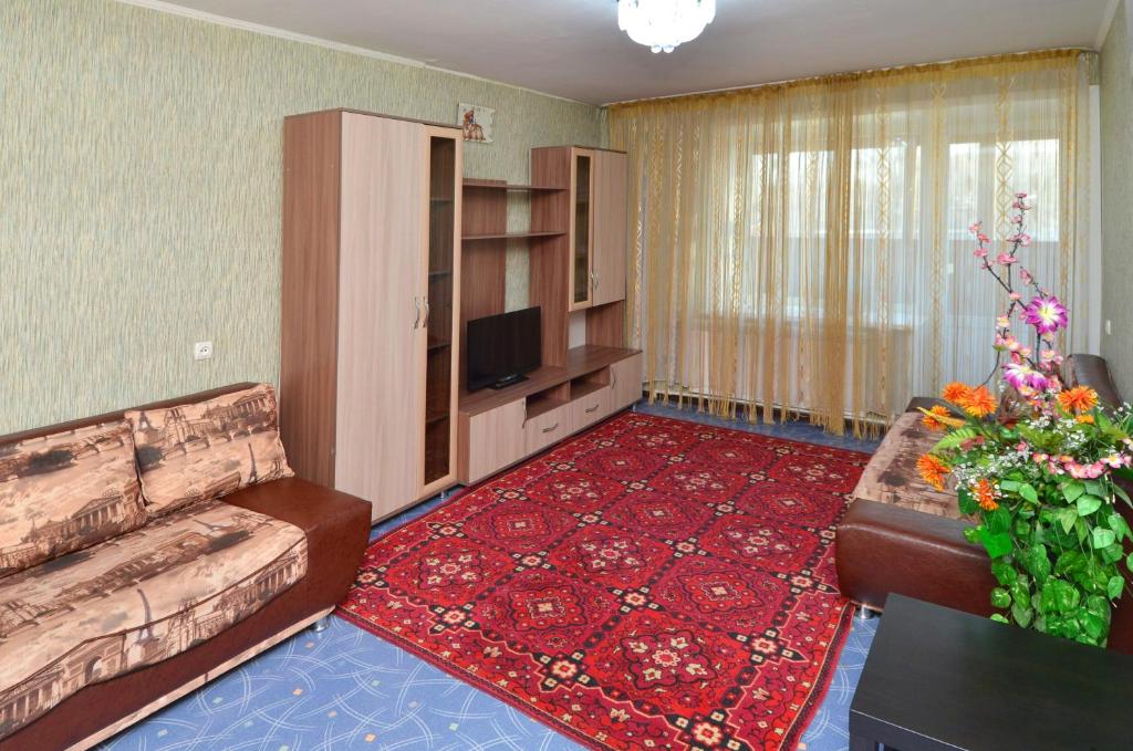 sala de estar con sofá y TV en 1 комнатные апартаменты на Садуакасова 24, en Kokshetau