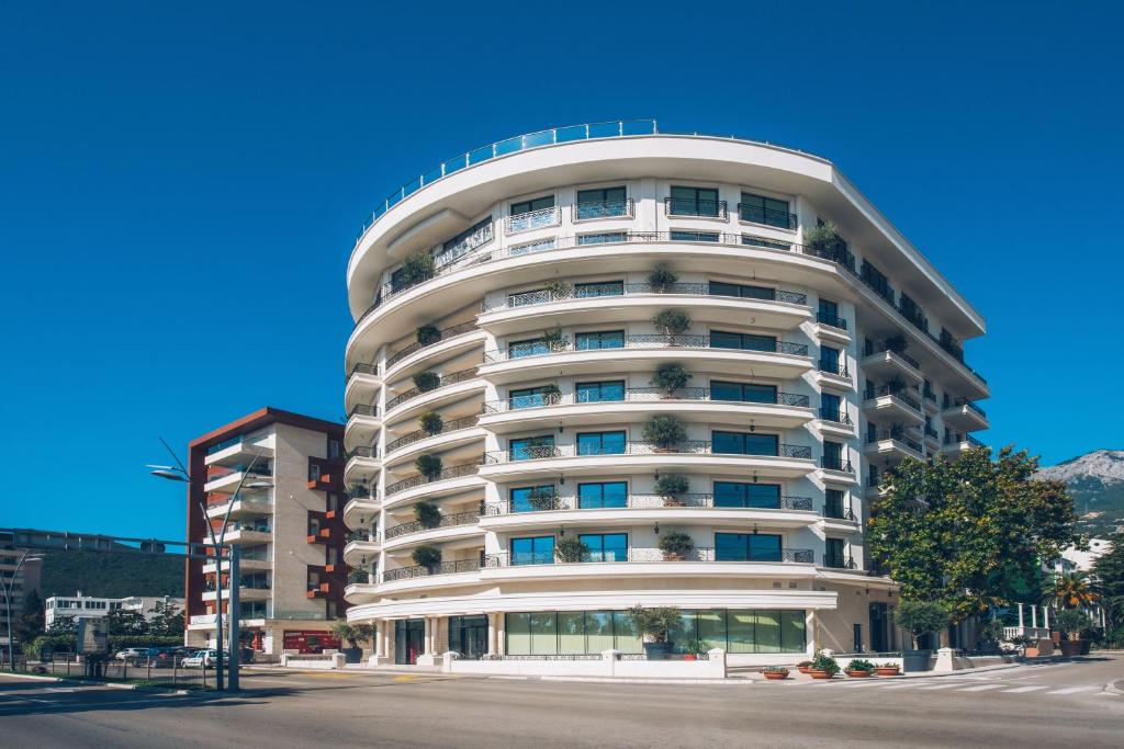 a tall white building with plants on it at Iberostar Waves Slavija in Budva