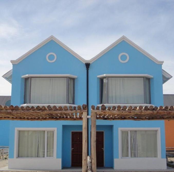 una casa azul con dos ventanas en la parte superior en Complejo La Celeste en Playas Doradas