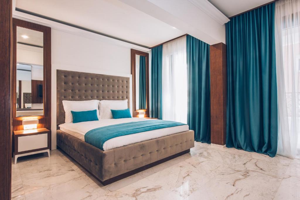 a bedroom with a large bed with blue pillows at Iberostar Waves Slavija in Budva