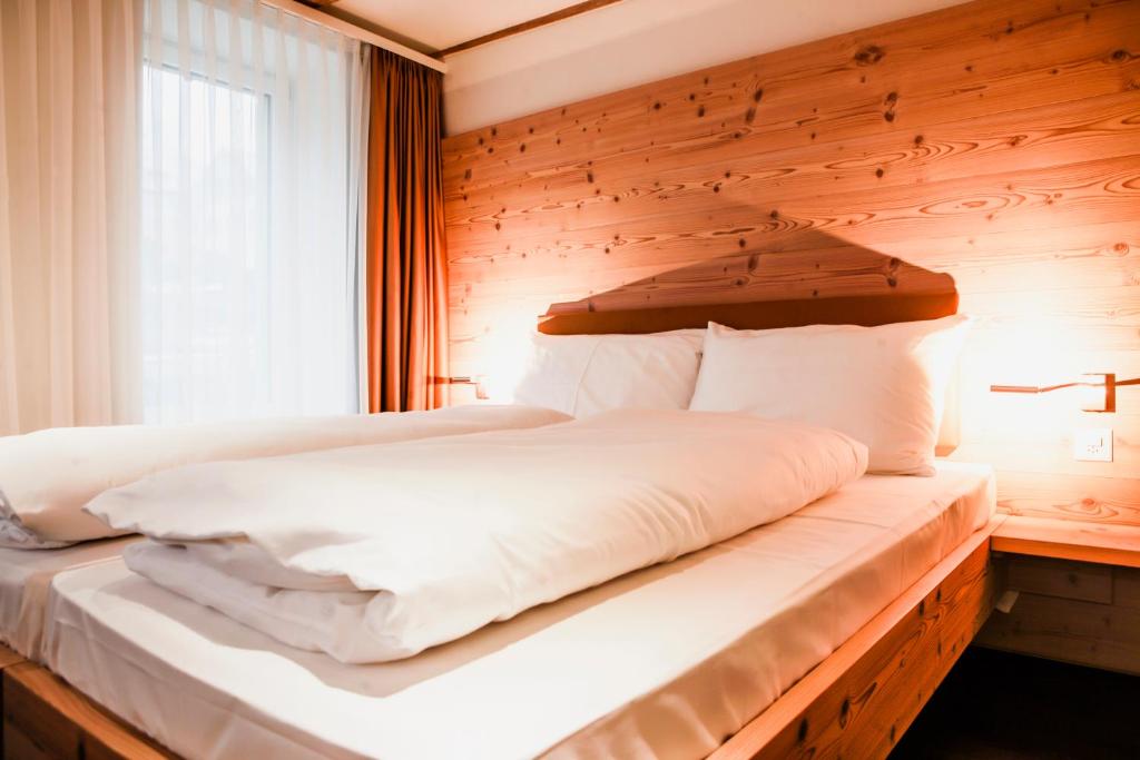 a bedroom with a bed with a wooden wall at Gasthaus zur Waldegg in Luzern