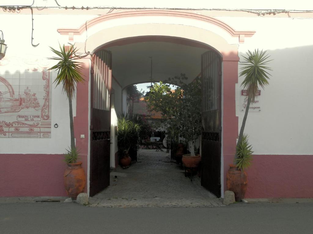 an entrance to a pink and white building with potted plants at Antiga Moagem in Vimieiro