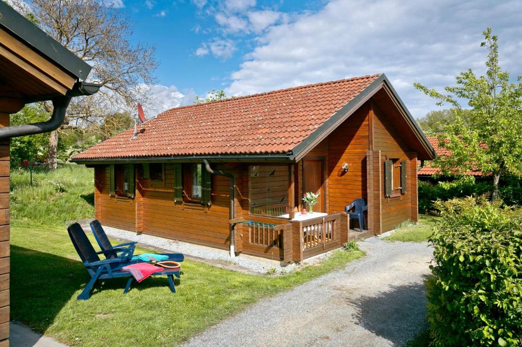 eine Holzhütte mit einer Terrasse und 2 Stühlen in der Unterkunft KNAUS Campingpark Viechtach in Viechtach