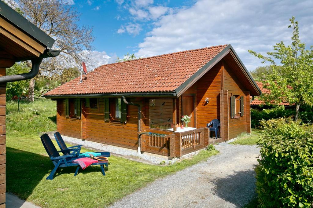 Cabaña de madera con terraza y 2 sillas en KNAUS Campingpark Viechtach, en Viechtach