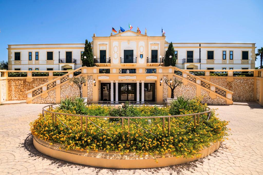 un edificio con un letto a fiori di fronte ad esso di Delfino Beach Hotel a Marsala