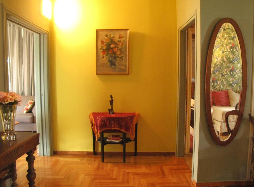 a yellow room with a table and a mirror at 'Arnis' duplex suite by 'Megaron Moussikis' Athens in Athens